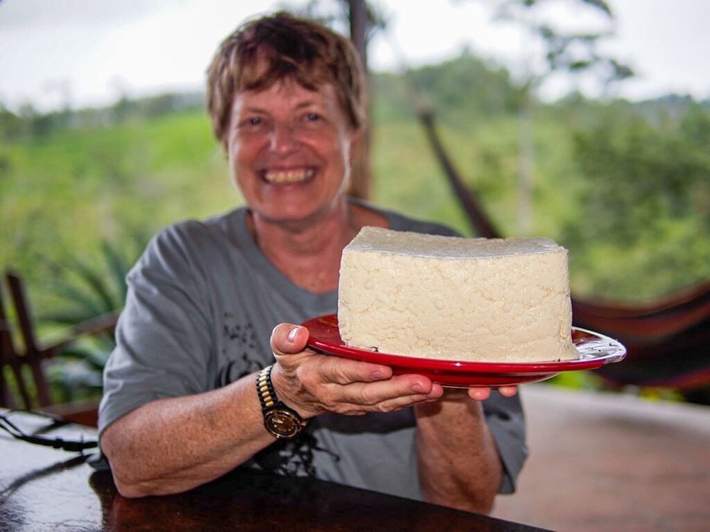 Tourist in La Fortuna enjoying an authentic Pura Vida experience making cheese at the farm