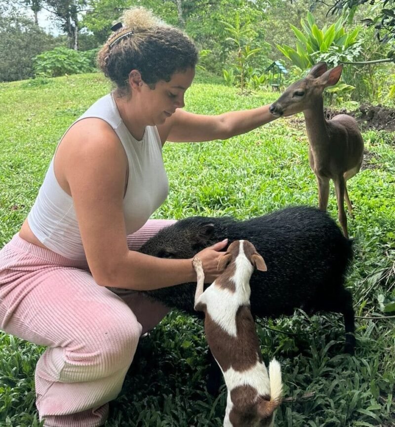 Family tourist gently interacting with farm animals during an authentic, hands-on farm tour near La Fortuna, highlighting the rural Costa Rica Pura Vida experience.
