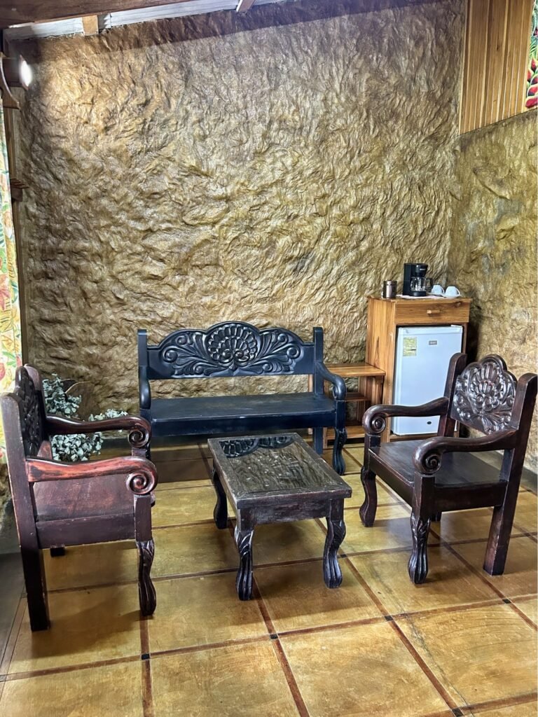 Rustic seating area in Room 3 at Casa Vista del Valle, a charming farm stay in Arenal, featuring traditional wooden furniture and a cozy atmosphere for families.